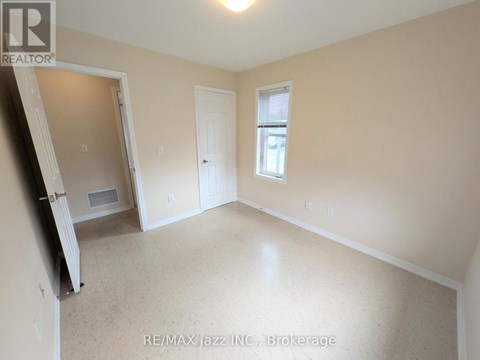 A room with a door, window, and a wall-mounted air conditioner unit.