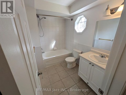 A bathroom with a toilet, sink, and bathtub.
