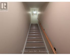A long flight of stairs leading to a light at the end.