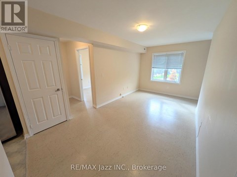 A room with a door, a window, and a light on the ceiling.