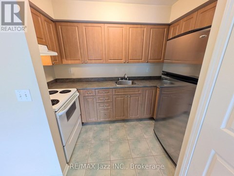 A kitchen with wooden cabinets and a stove top oven.