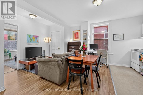 A living room with a brown couch and a wooden table.