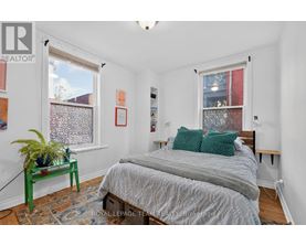 A bedroom with a bed, nightstand, and window.