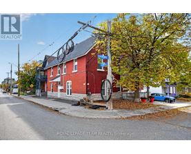 A red brick building with a sign that says "Royal LePage Team Realty, Brokerage" in front of it.