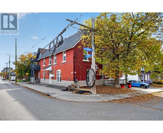 A red brick building with a sign that says "Royal LePage Team Realty, Brokerage" in front of it.