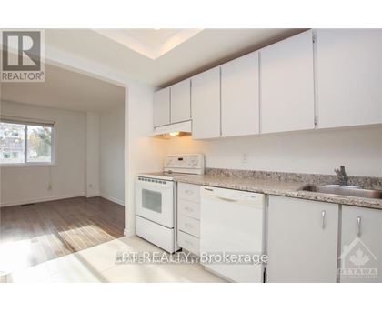 A kitchen with white cabinets and appliances is for sale.
