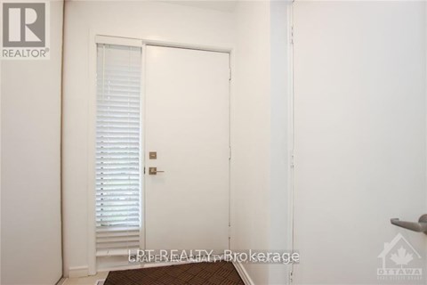 A white door with blinds is in a room with a brown rug.