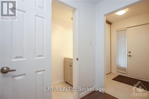 A white door with a handle and a small cabinet underneath it.