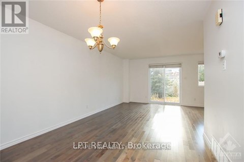 A room with wooden floors and a chandelier hanging from the ceiling.