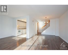 A spacious living room with a staircase leading to the upper floor.