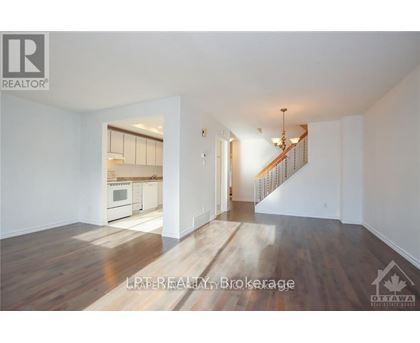 A spacious living room with a staircase leading to the upper floor.