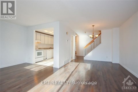 A spacious living room with a staircase leading to the upper floor.