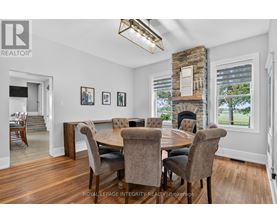 A dining room with a stone fireplace and a table set for six.