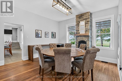 A dining room with a stone fireplace and a table set for six.