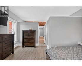 A bedroom with a bed, dresser, and chest of drawers.