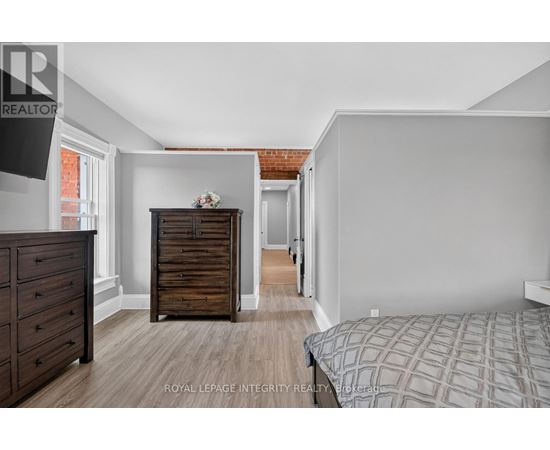 A bedroom with a bed, dresser, and chest of drawers.