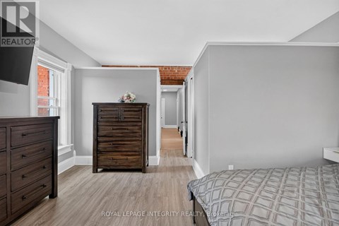 A bedroom with a bed, dresser, and chest of drawers.