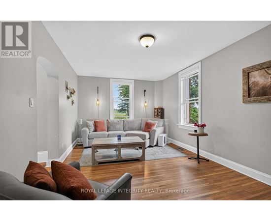 A living room with a grey couch and a wooden floor.