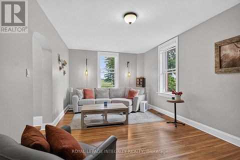A living room with a grey couch and a wooden floor.