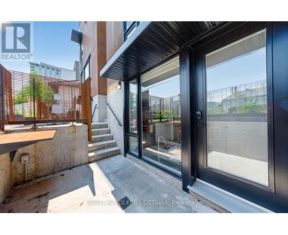 A modern house entrance with a glass door and a wooden railing.