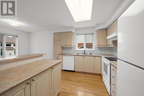 A kitchen with wooden cabinets and a white refrigerator.