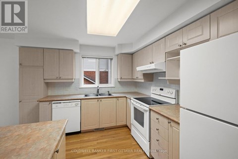 A kitchen with white appliances and wooden cabinets.