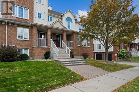 A brick apartment building with a tree in front.