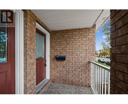 A red door is on the left side of a brick wall.