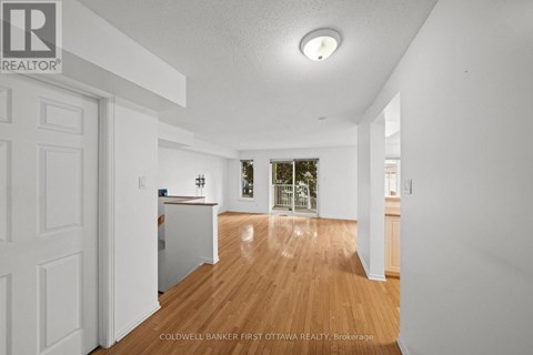A spacious room with wooden floors and white walls.