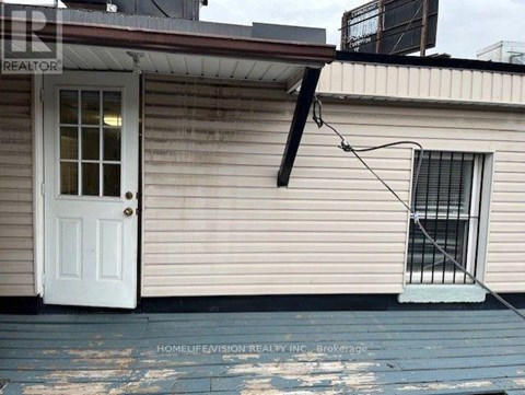 A small house with a white door and a window with bars.