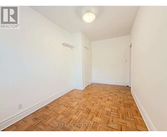 A room with wooden flooring and white walls.