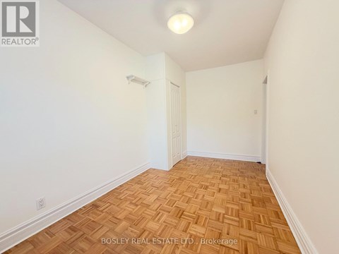 A room with wooden flooring and white walls.
