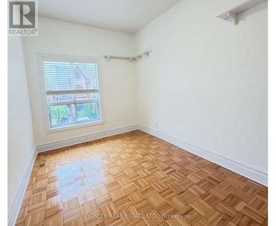 A room with wooden flooring and a window.