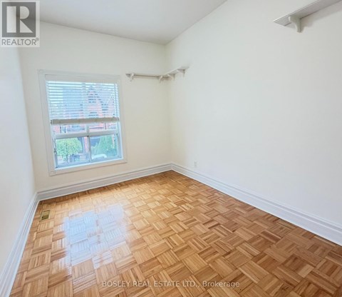 A room with wooden flooring and a window.