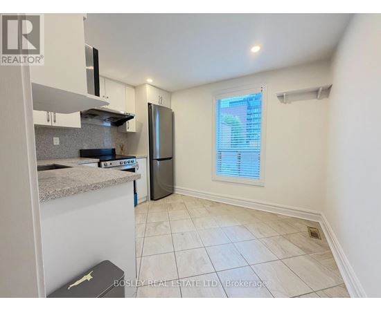 A kitchen with a refrigerator, microwave, and a countertop.