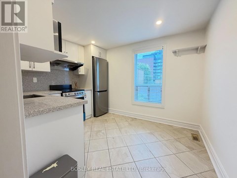 A kitchen with a refrigerator, microwave, and a countertop.