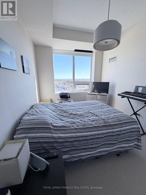 A bedroom with a large bed and a desk with a laptop.