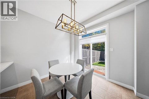 A dining room with a table and chairs and a window.