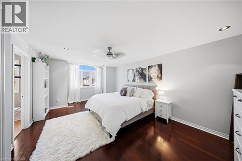 A bedroom with a white bed and a white rug.