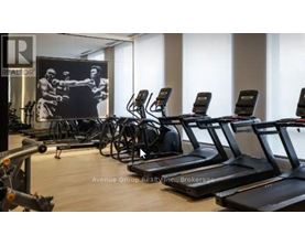 A gym with treadmills and a poster of a boxer.