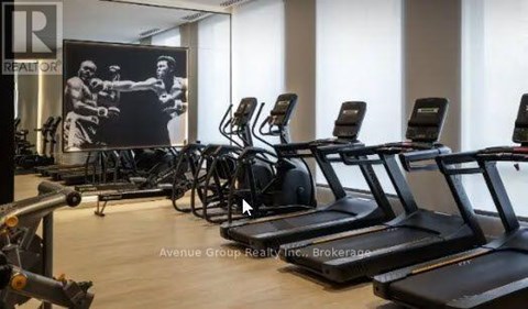 A gym with treadmills and a poster of a boxer.