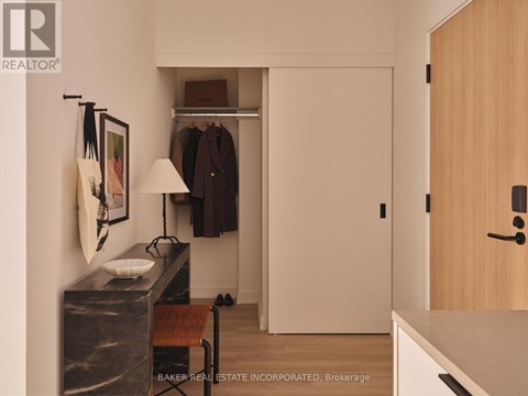 A room with a marble table and a bench with a coat rack and a lamp.