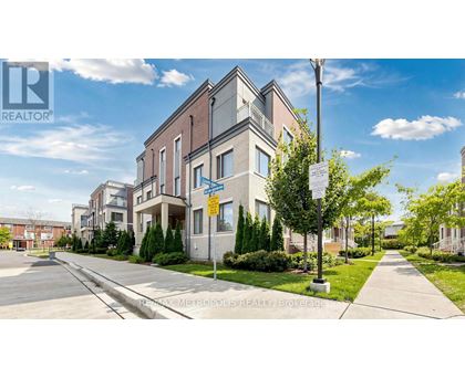 A street view of a residential area with apartment buildings and a realtor logo.