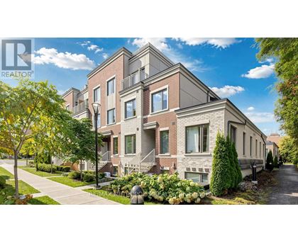 A row of houses with a realtor logo in the corner.