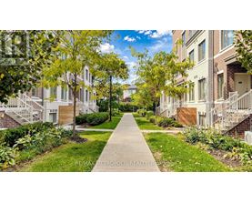 A tree-lined walkway leads to apartment buildings.