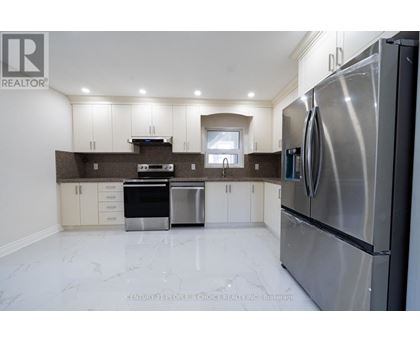 A modern kitchen with stainless steel appliances and white marble flooring.