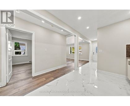 A spacious room with marble flooring and white walls.