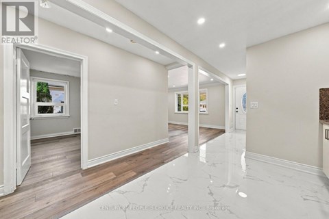 A spacious room with marble flooring and white walls.