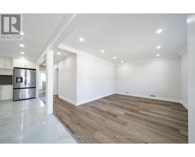 A spacious room with wooden flooring and white walls.