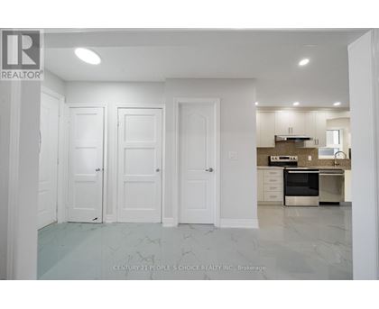 A kitchen with white cabinets and a marble floor.